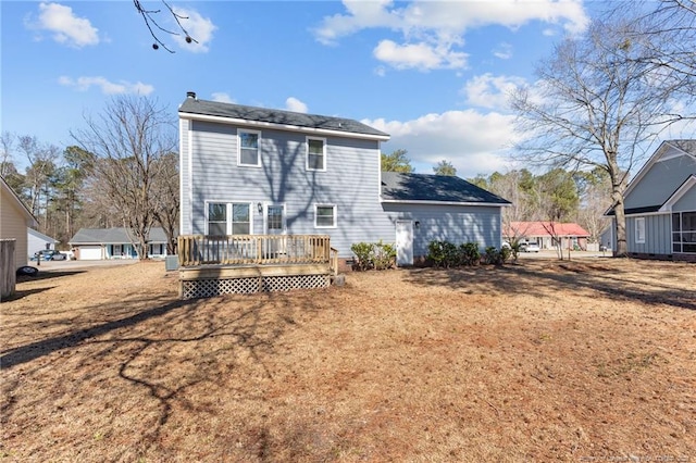 back of house with a lawn and a deck