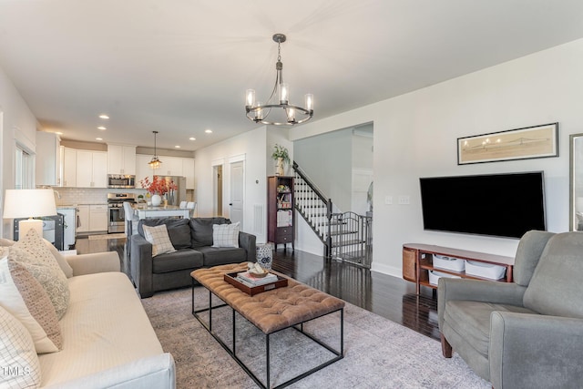 living area featuring baseboards, stairway, an inviting chandelier, light wood-type flooring, and recessed lighting