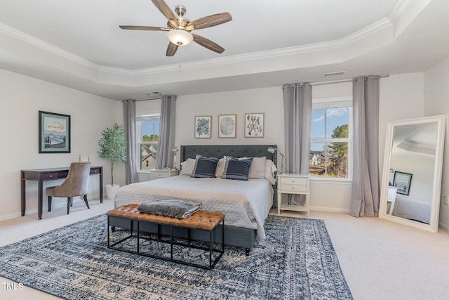 carpeted bedroom featuring visible vents, a tray ceiling, baseboards, and ornamental molding