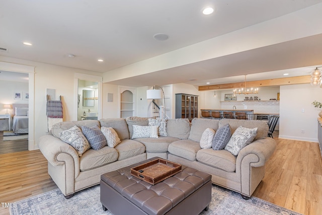 living room with light wood-style flooring, visible vents, baseboards, and recessed lighting