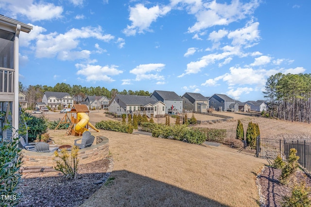 view of yard featuring a residential view, a playground, and fence