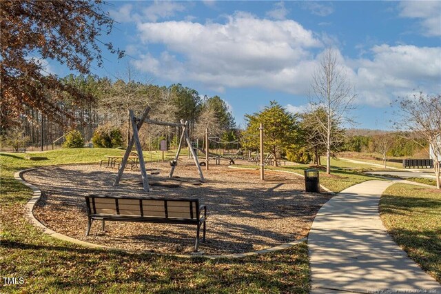 view of home's community featuring playground community and a lawn