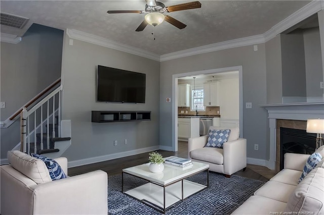 living area with ornamental molding, a fireplace, visible vents, and baseboards