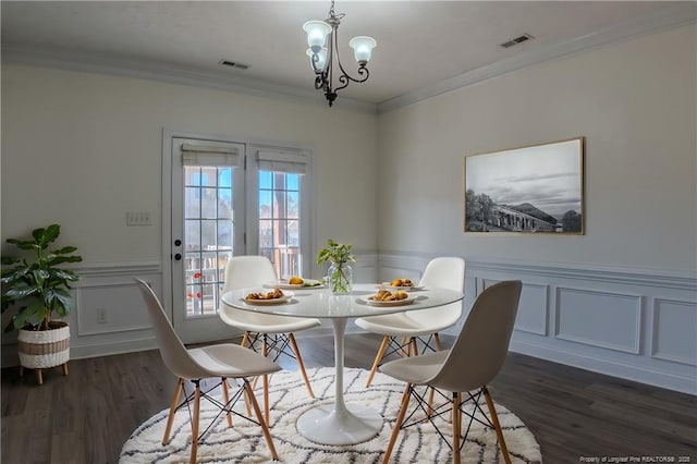 dining area featuring dark wood-type flooring, visible vents, and crown molding