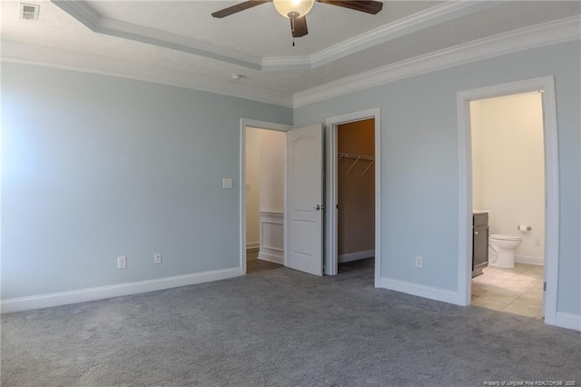 unfurnished bedroom with light carpet, visible vents, ornamental molding, and a raised ceiling