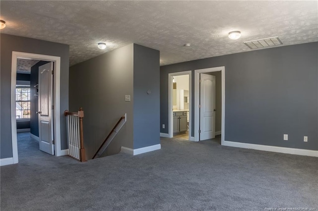 spare room with baseboards, visible vents, and carpet flooring