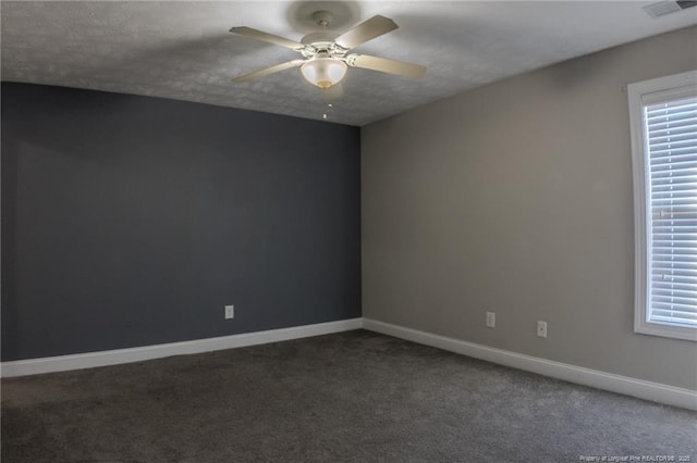 unfurnished room featuring visible vents, baseboards, a ceiling fan, dark colored carpet, and a textured ceiling