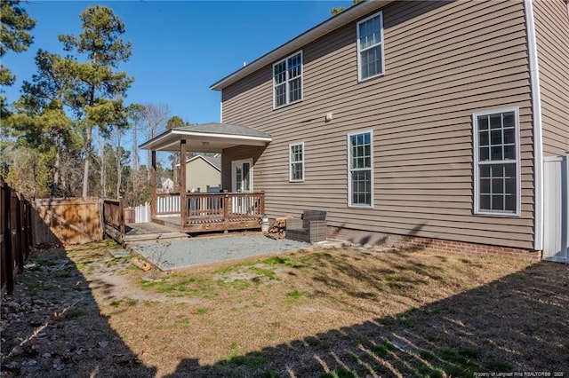 rear view of house featuring a fenced backyard, a lawn, and a deck