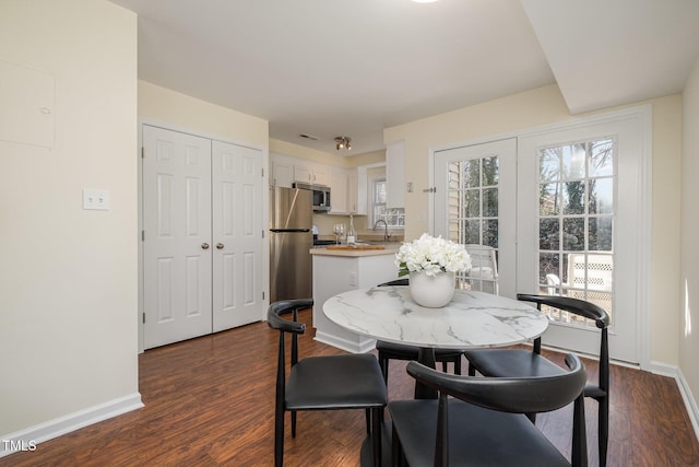 dining area with dark wood-style flooring, visible vents, and baseboards