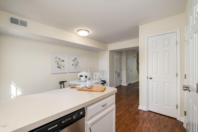 kitchen with visible vents, dark wood-style floors, light countertops, white cabinetry, and stainless steel dishwasher