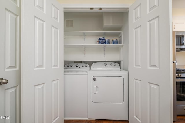 laundry room with laundry area, separate washer and dryer, and visible vents