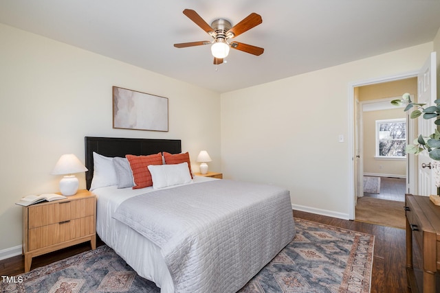 bedroom with dark wood finished floors, a ceiling fan, and baseboards