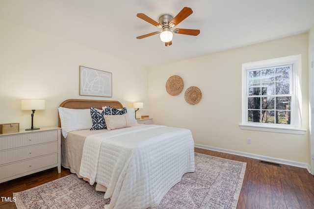 bedroom featuring baseboards, visible vents, ceiling fan, and dark wood-type flooring