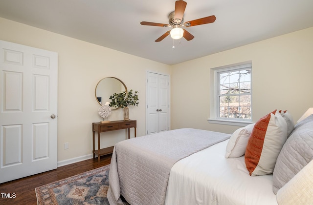 bedroom with dark wood-style floors, a ceiling fan, and baseboards