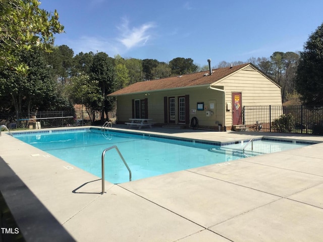 community pool with a patio, french doors, and fence