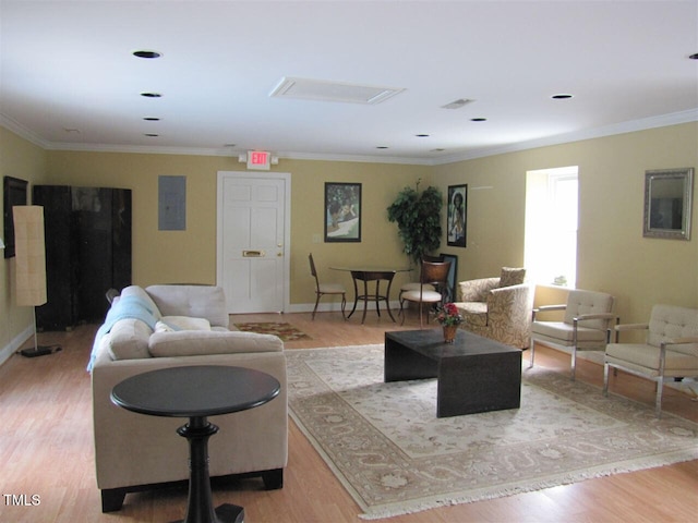 living area featuring ornamental molding, electric panel, baseboards, and wood finished floors