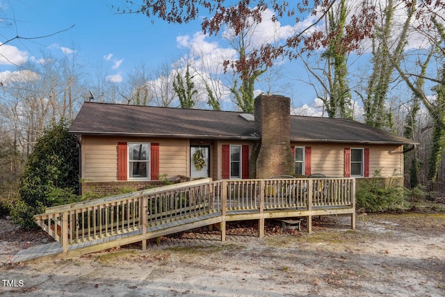 ranch-style house with a chimney and a wooden deck