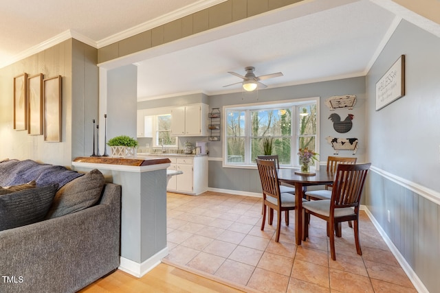 kitchen featuring light countertops, a peninsula, white cabinetry, and crown molding