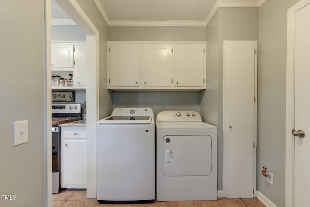 clothes washing area with light tile patterned floors, washer and clothes dryer, cabinet space, and crown molding