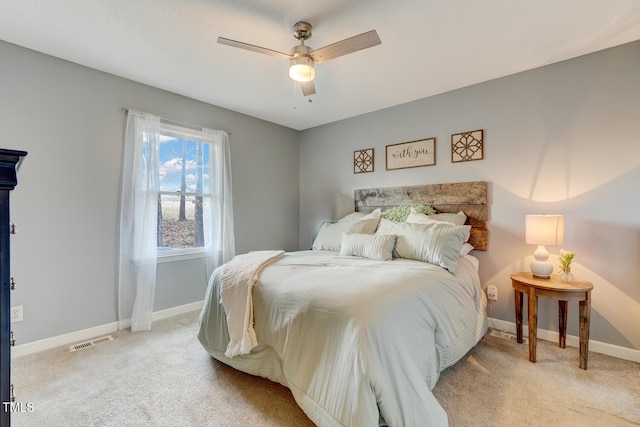 bedroom featuring baseboards, visible vents, and light colored carpet