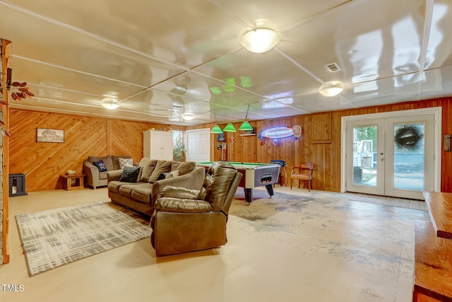 interior space featuring concrete flooring, pool table, visible vents, and wooden walls