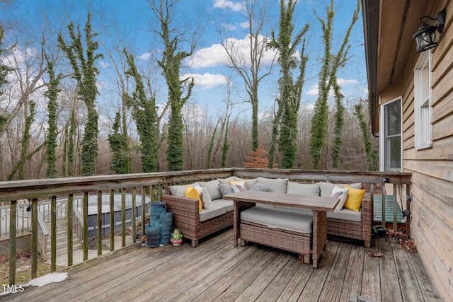 wooden deck with a forest view and outdoor lounge area