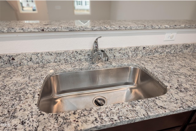 room details with light stone counters and a sink