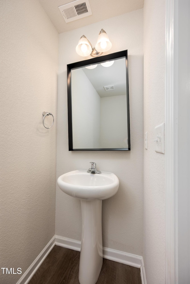 bathroom with wood finished floors, visible vents, and baseboards