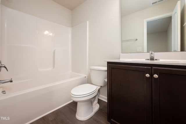 bathroom with visible vents, shower / bathing tub combination, toilet, vanity, and wood finished floors