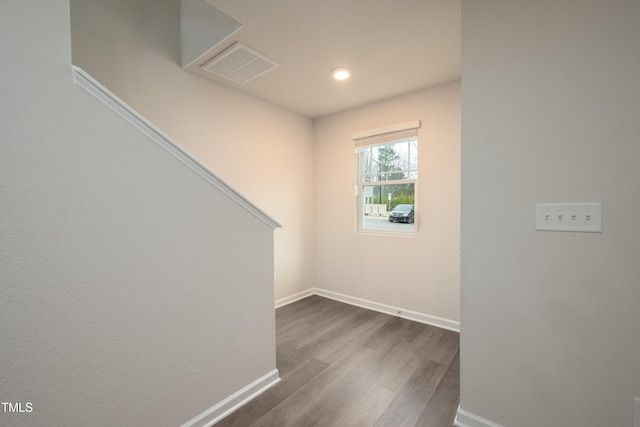 unfurnished room featuring baseboards, visible vents, and dark wood-type flooring