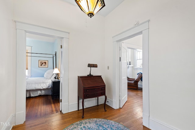 corridor featuring hardwood / wood-style flooring and baseboards