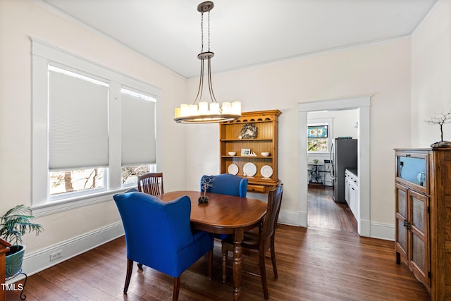 dining space with an inviting chandelier, dark wood-type flooring, baseboards, and a wealth of natural light