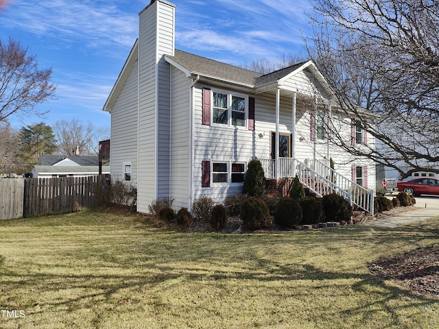 view of front of house featuring a front lawn, a chimney, a shingled roof, and fence