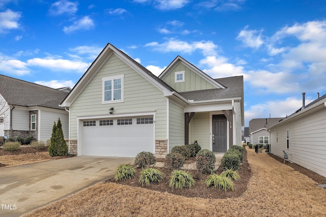 view of front of house with board and batten siding, stone siding, driveway, and a garage