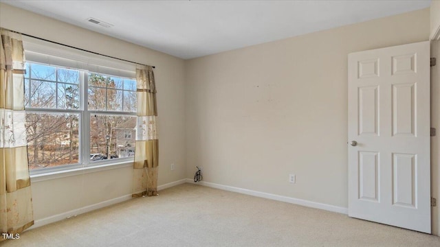 unfurnished room featuring light carpet, visible vents, and baseboards