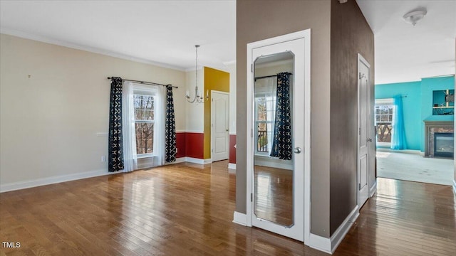 interior space featuring crown molding, dark wood finished floors, and baseboards