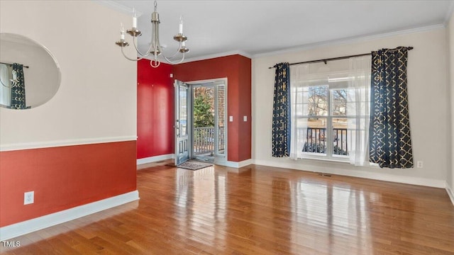 unfurnished dining area featuring plenty of natural light, wood finished floors, an inviting chandelier, and crown molding