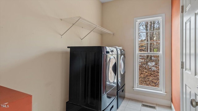 laundry room with laundry area, light tile patterned floors, visible vents, and separate washer and dryer