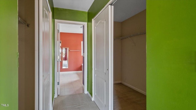 hall featuring light carpet and baseboards