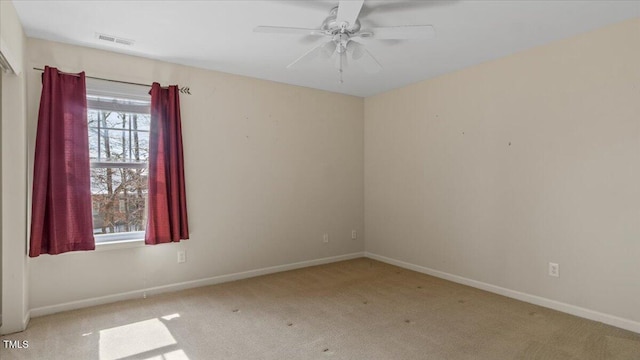 unfurnished room with ceiling fan, visible vents, baseboards, and light colored carpet