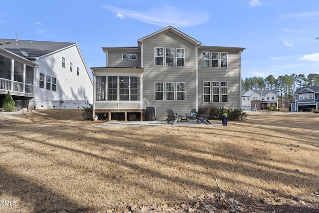 back of house with a sunroom, a patio area, and a yard