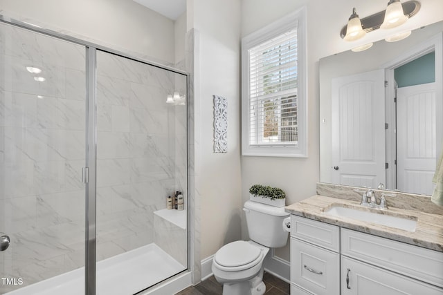 full bath with baseboards, a shower stall, toilet, and vanity