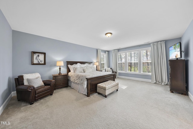 bedroom with light carpet and baseboards