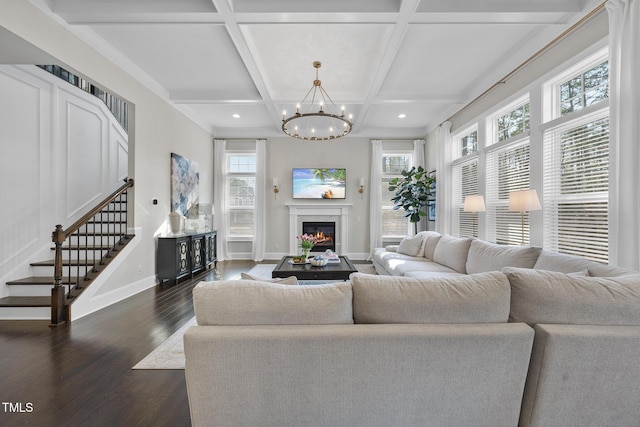 living room with coffered ceiling, a high end fireplace, baseboards, stairs, and dark wood-style floors