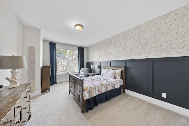 carpeted bedroom with brick wall and baseboards