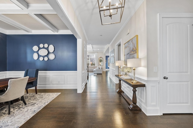 interior space featuring wainscoting, a notable chandelier, beam ceiling, and wood finished floors