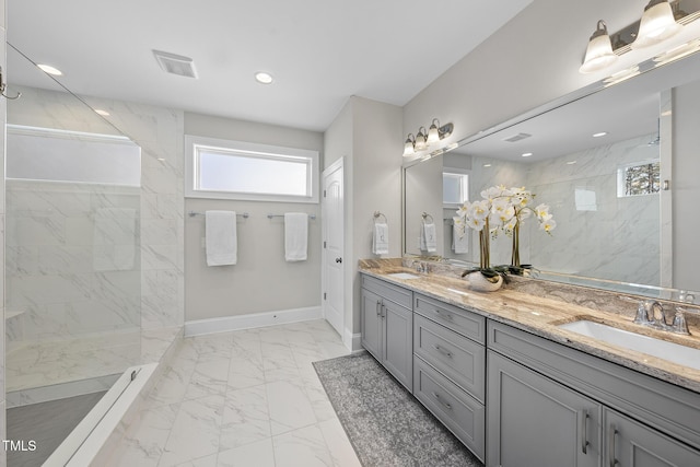 full bath featuring baseboards, visible vents, marble finish floor, a walk in shower, and a sink