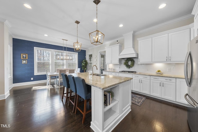 kitchen with custom range hood, ornamental molding, a notable chandelier, stainless steel appliances, and a sink