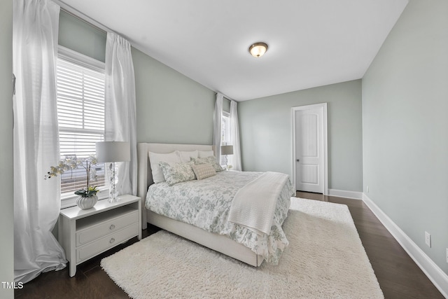 bedroom featuring dark wood-style floors and baseboards