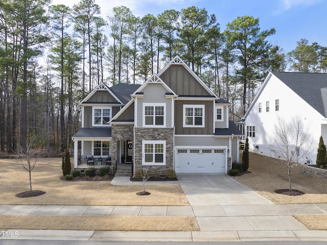 craftsman-style home featuring a porch, an attached garage, stone siding, driveway, and board and batten siding